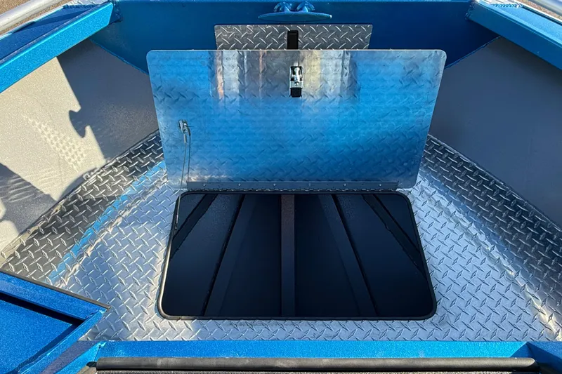 Slide: The Image of 2026 Alumaweld Intruder Outboard 22 boat with open storage compartment and diamond plate flooring. - 15
