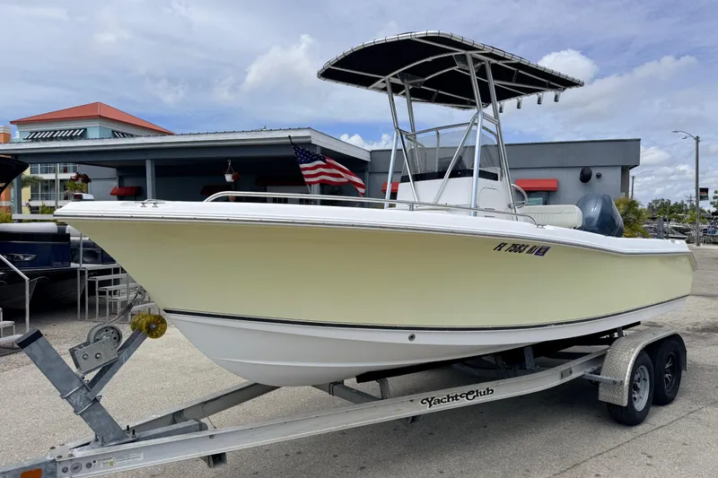The Image of 2007 Sea Hunt Triton 220 boat on trailer, parked outdoors with American flag. - 0