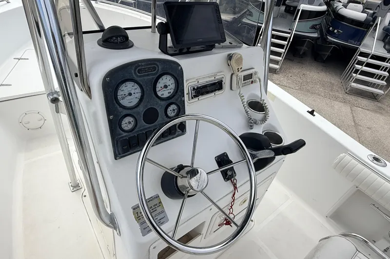 Slide: The Image of 2007 Sea Hunt Triton 220 boat console with steering wheel and navigation instruments. - 15