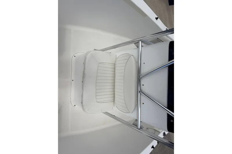 Slide: The Image of 2007 Sea Hunt Triton 220 boat seat with white upholstery and metal railing. - 12