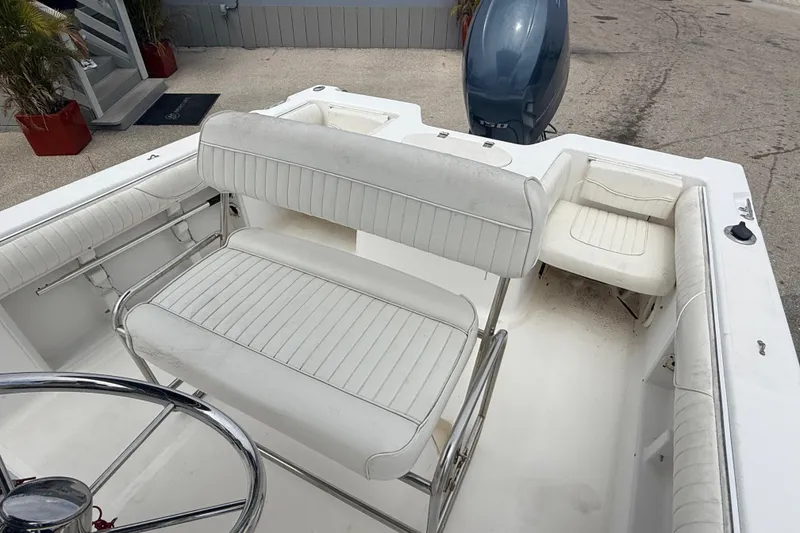 Slide: The Image of 2007 Sea Hunt Triton 220 boat interior with white seating and steering wheel. - 14