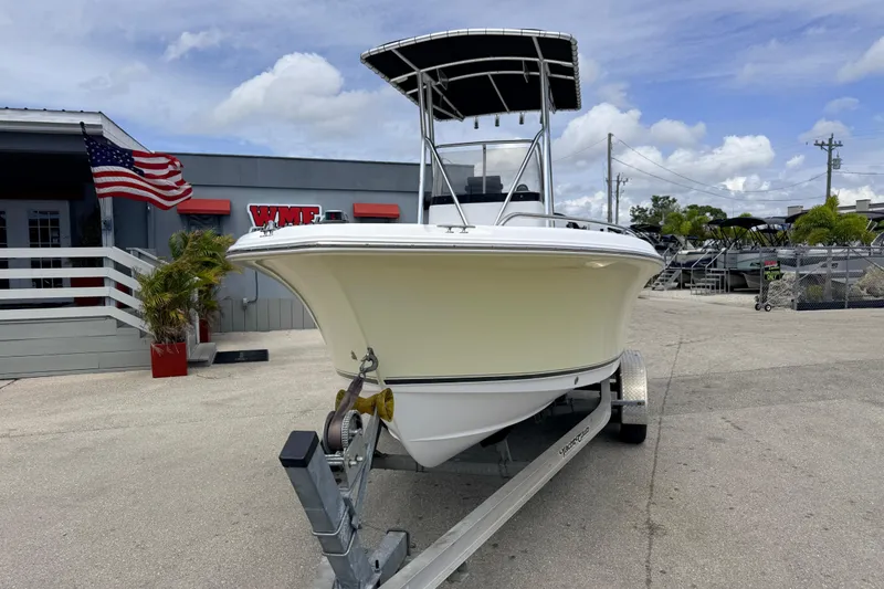 Slide: The Image of 2007 Sea Hunt Triton 220 boat on trailer, parked outside dealership with American flag. - 2