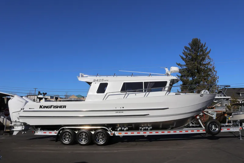 The Image of 2026 KingFisher 3425 GFX Offshore boat on trailer under clear blue sky. - 1