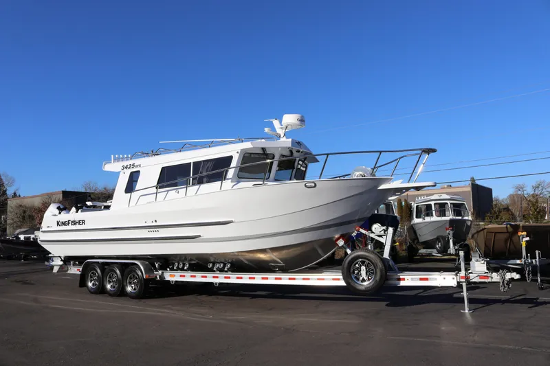 Slide: The Image of 2026 KingFisher 3425 GFX Offshore boat on trailer under clear blue sky. - 2