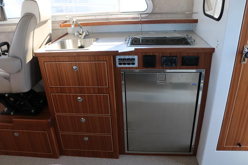Slide: The Image of Compact kitchen area in 2026 KingFisher 3425 GFX Offshore boat with sink, stove, and fridge. - 39
