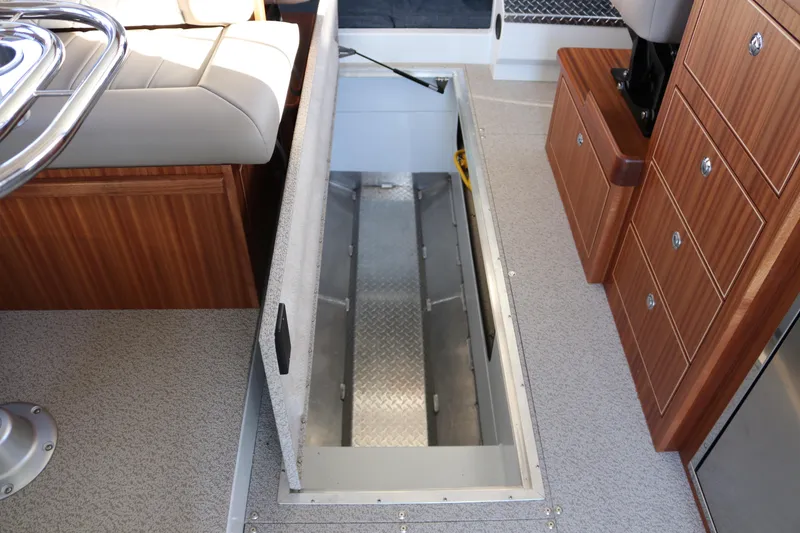 Slide: The Image of Interior view of 2026 KingFisher 3425 GFX Offshore boat with open storage compartment. - 47