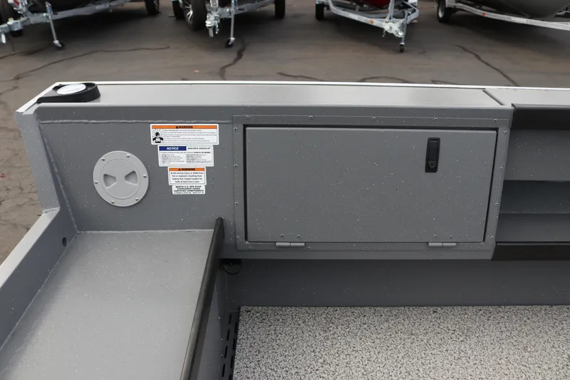 Slide: The Image of 2026 Alumaweld Columbia 23 boat interior with storage compartment and safety labels. - 23