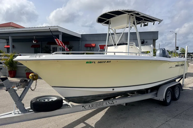 The Image of 2006 Sea Hunt Triton 220 boat on trailer, parked outside a building. - 0