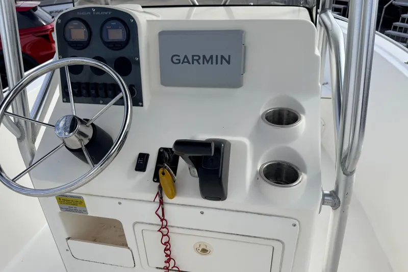 Slide: The Image of 2006 Sea Hunt Triton 220 boat console with Garmin navigation system and steering wheel. - 12