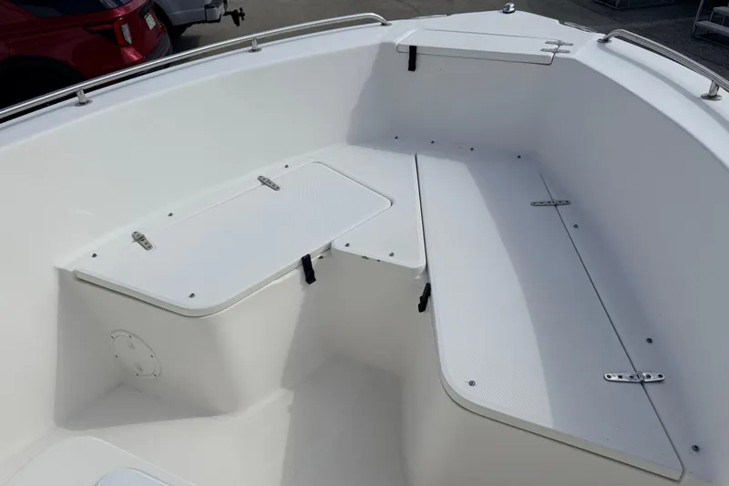 Slide: The Image of 2006 Sea Hunt Triton 220 boat interior with white seating and storage compartments. - 13