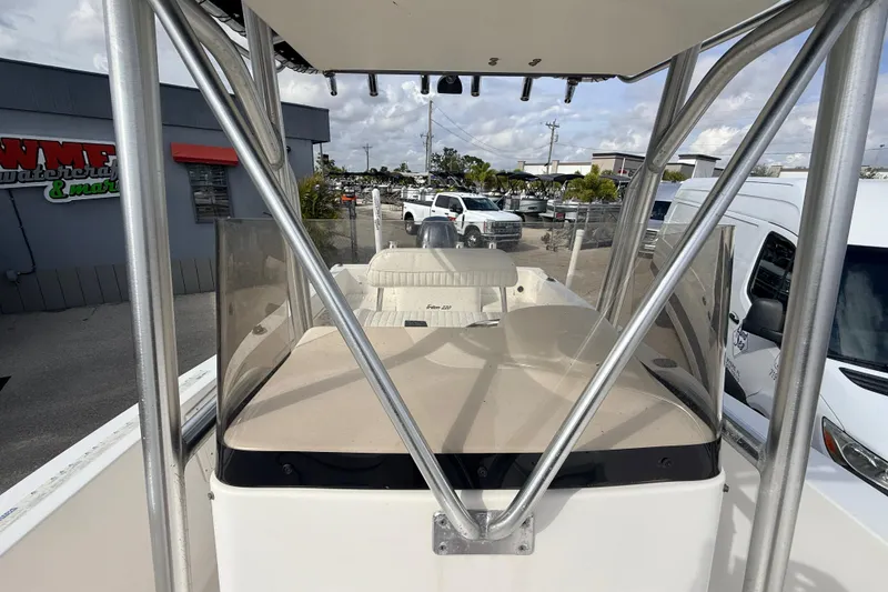 Slide: The Image of 2006 Sea Hunt Triton 220 boat with T-top and seating, parked at a marina. - 16