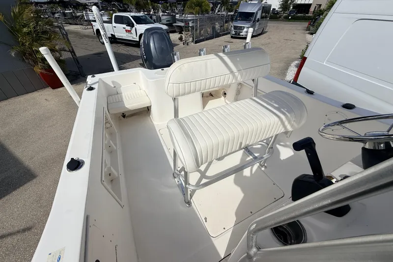 Slide: The Image of 2006 Sea Hunt Triton 220 boat interior with white seating and steering wheel. - 17