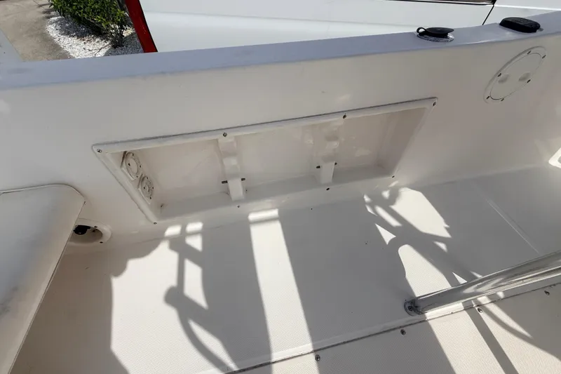 Slide: The Image of 2006 Sea Hunt Triton 220 boat interior, featuring a storage compartment and clean white deck. - 19