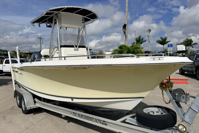 Slide: The Image of 2006 Sea Hunt Triton 220 boat on trailer, parked outdoors under cloudy sky. - 4