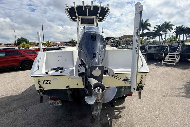 Slide: The Image of 2006 Sea Hunt Triton 220 boat with outboard motor, parked outdoors. - 7