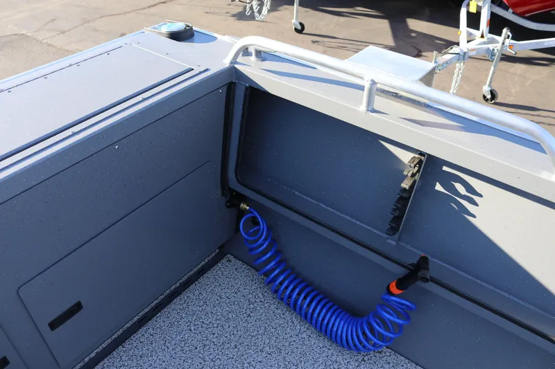 Slide: The Image of 2026 Alumaweld Intruder Outboard 20 boat interior with blue coiled hose and storage compartment. - 18