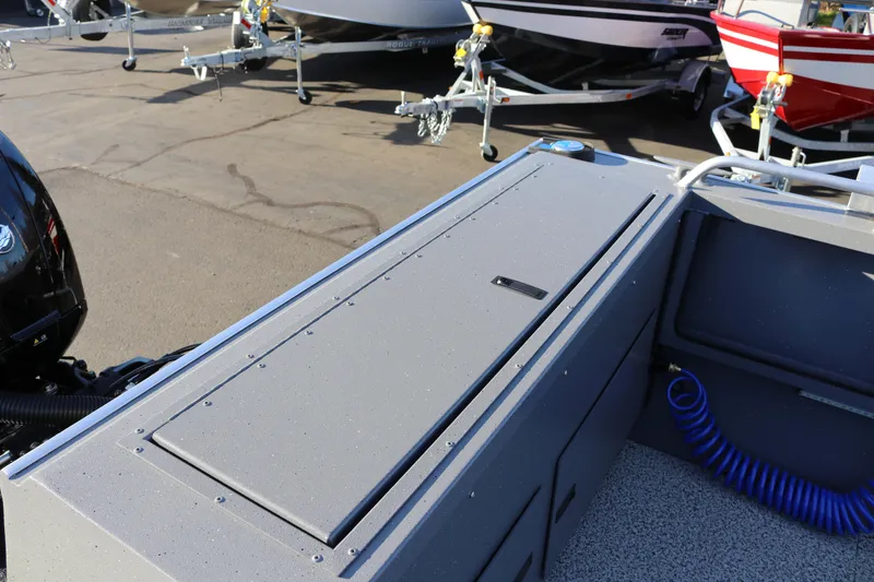 Slide: The Image of 2026 Alumaweld Intruder Outboard 20 boat interior with storage compartment and trailer view. - 21
