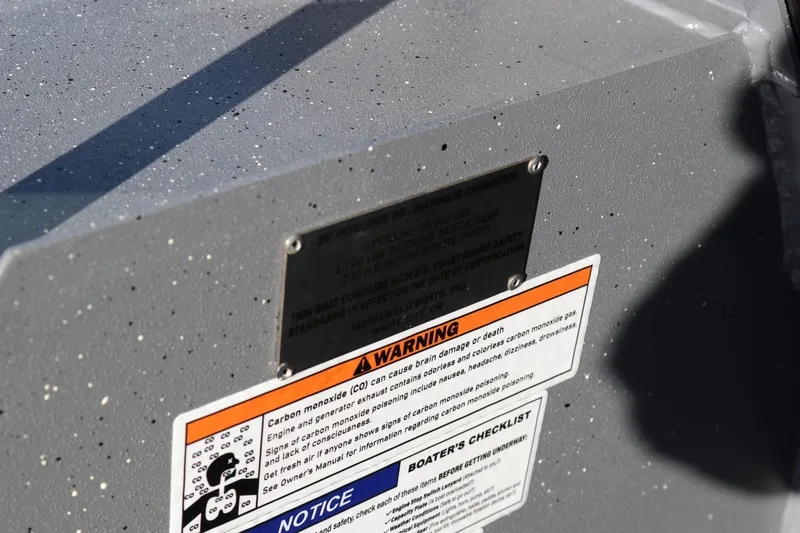 Slide: The Image of 2026 Alumaweld Intruder Outboard 20 warning label on speckled gray surface. - 26