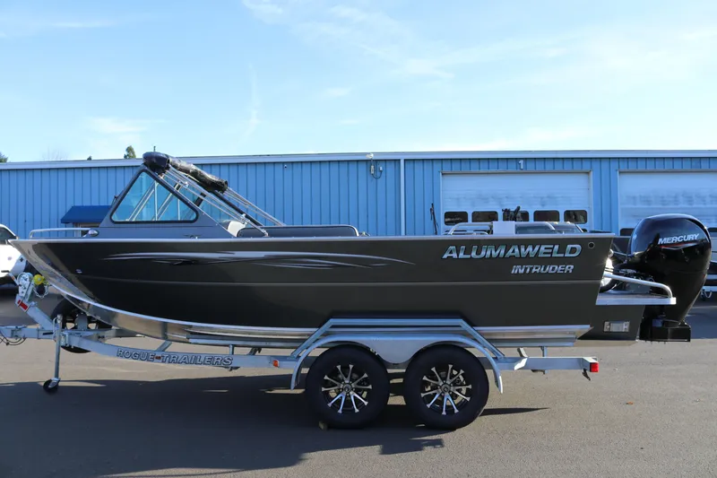Slide: The Image of 2026 Alumaweld Intruder Outboard 20 boat on trailer, side view, parked outdoors. - 3
