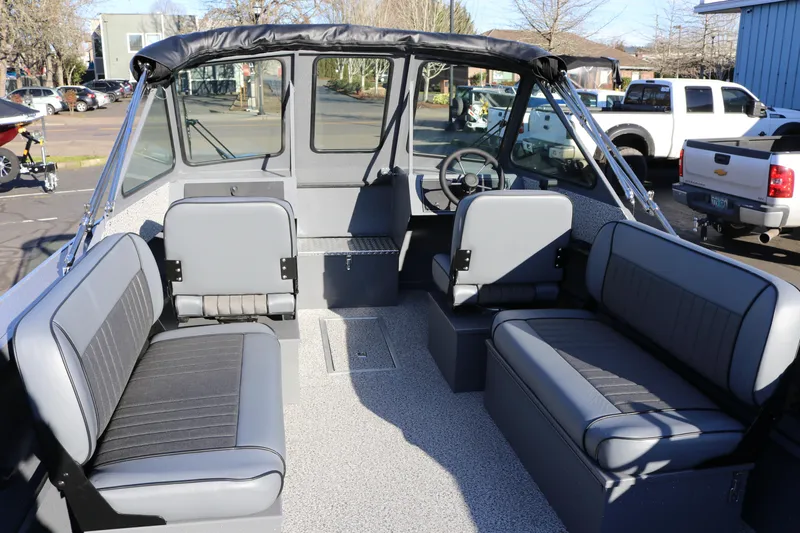 Slide: The Image of 2026 Alumaweld Intruder Outboard 20 boat interior with gray seating and steering console. - 7