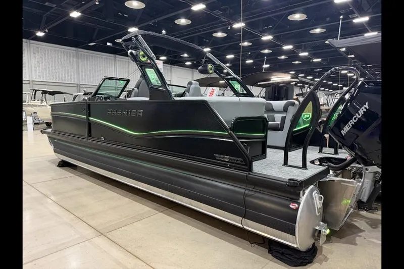 Slide: The Image of 2026 Premier 250 Solaris Sport pontoon boat displayed indoors with Mercury engine. - 2