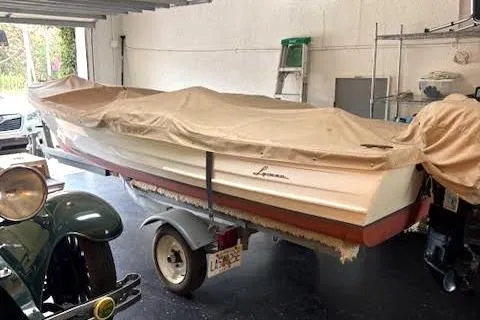 Slide: The Image of 1952 Lyman 15 Classic Runabout boat covered in a garage setting. - 3
