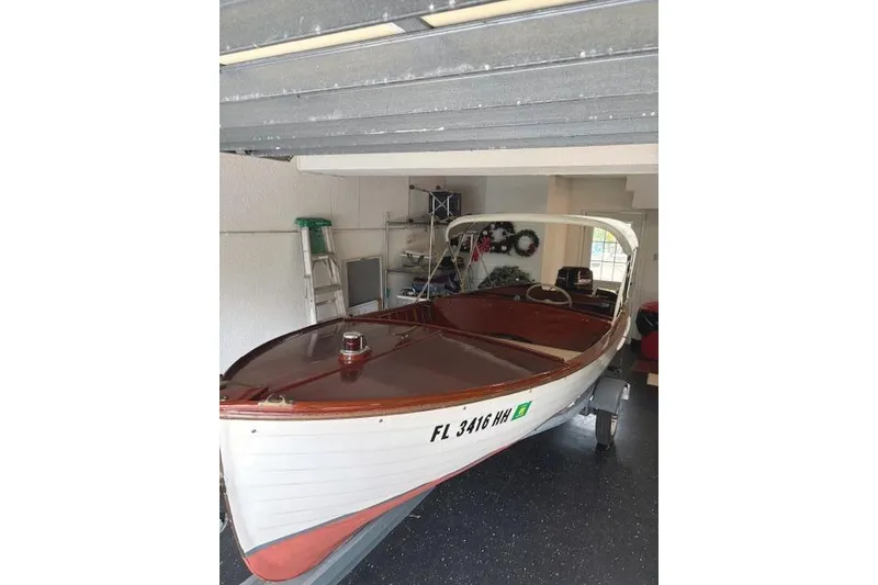 Slide: The Image of 1952 Lyman 15 Classic Runabout boat in garage, white hull, wooden interior. - 5
