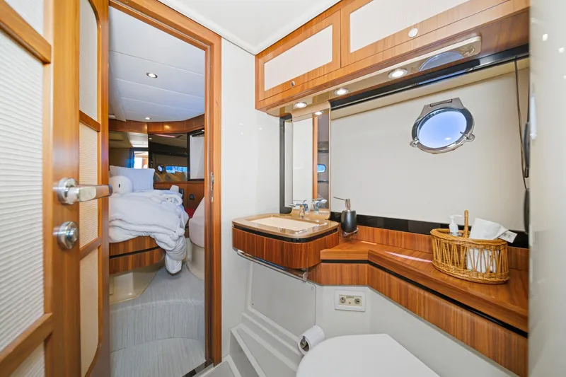 Slide: The Image of Luxurious bathroom interior on 2013 Azimut Magellano 50 yacht, featuring wood accents and porthole. - 13