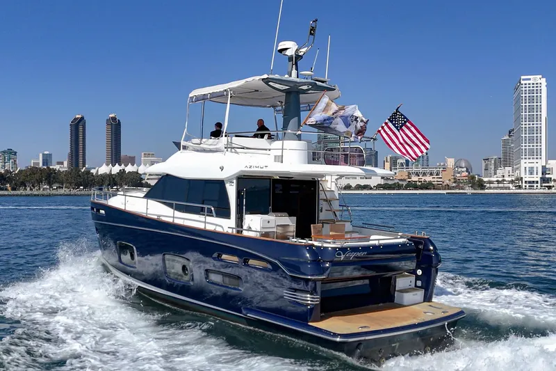 Slide: The Image of Azimut Magellano 50 yacht cruising near city skyline, 2013 model, with American flag. - 31