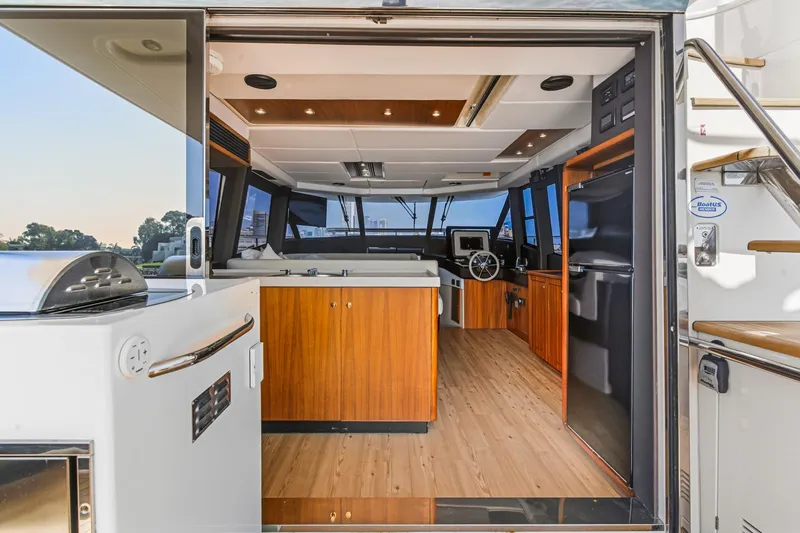 Slide: The Image of Interior view of 2013 Azimut Magellano 50 yacht, featuring modern wood finishes and helm station. - 80