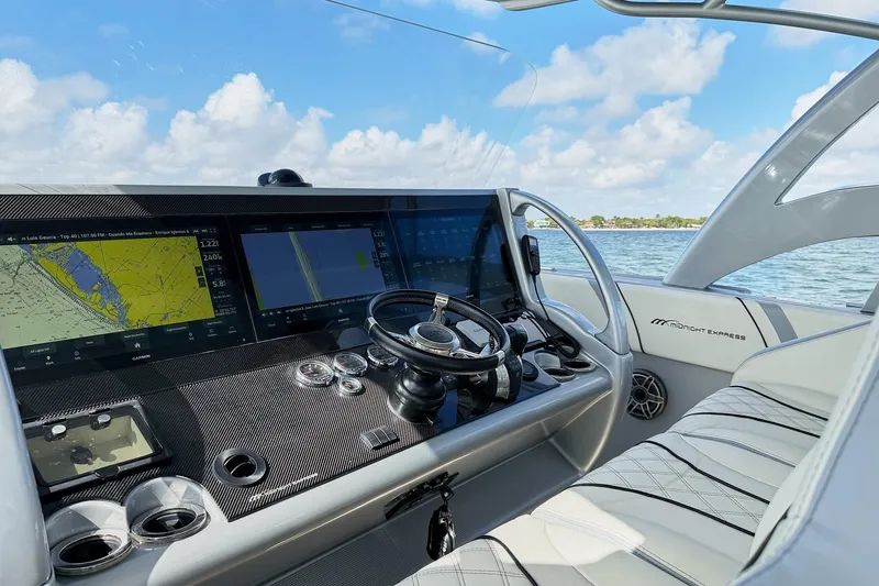 Slide: The Image of Cockpit of Midnight Express 43 Open boat with advanced navigation displays and steering wheel. - 12
