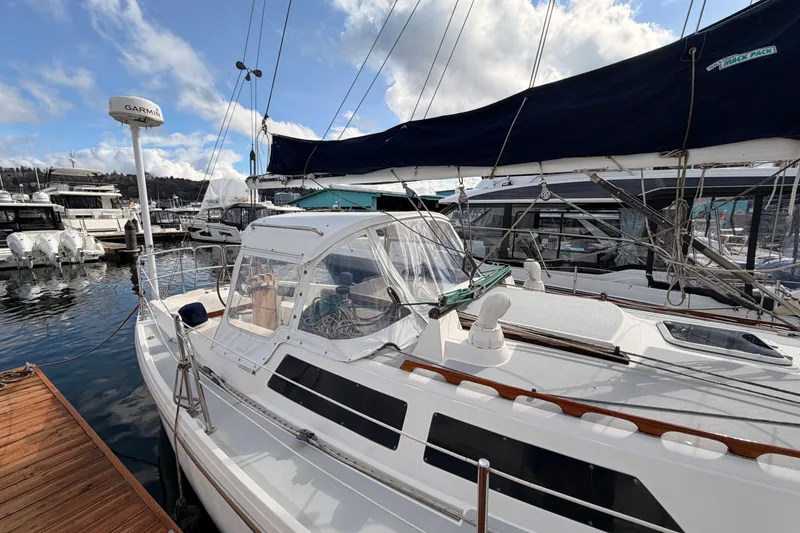 Slide: The Image of 1989 Catalina 34 sailboat docked at marina with clear skies and surrounding boats. - 15