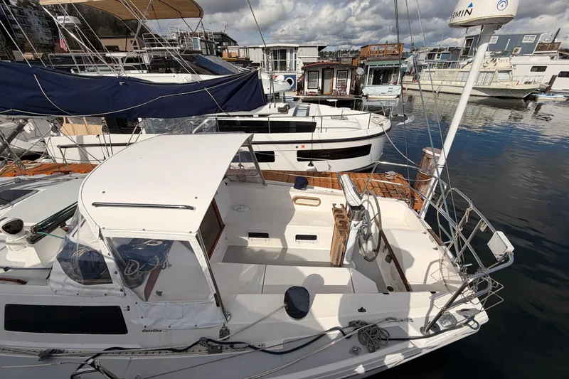 Slide: The Image of 1989 Catalina 34 sailboat docked in a marina, surrounded by other boats. - 18