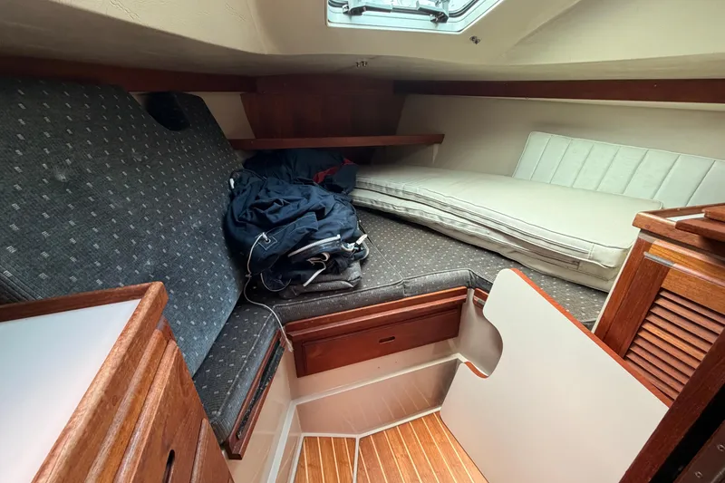 Slide: The Image of Cozy cabin interior of 1989 Catalina 34 sailboat with wooden accents and cushioned seating. - 23