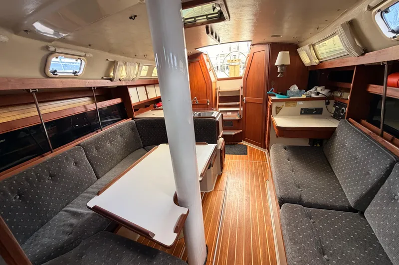 Slide: The Image of Interior of a 1989 Catalina 34 sailboat with cozy seating and wooden finishes. - 25