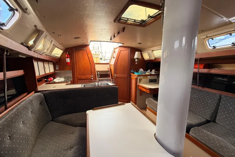 Slide: The Image of Interior of a 1989 Catalina 34 sailboat with cozy seating and wooden cabinetry. - 26