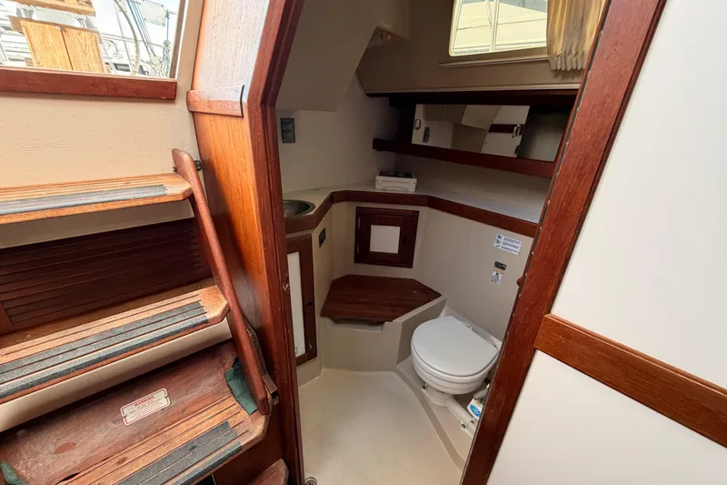 Slide: The Image of Interior of 1989 Catalina 34 sailboat showing compact bathroom with wooden accents. - 32