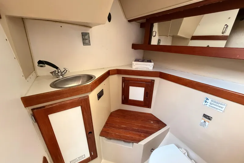 Slide: The Image of 1989 Catalina 34 yacht bathroom with sink, mirror, and wooden accents. - 33