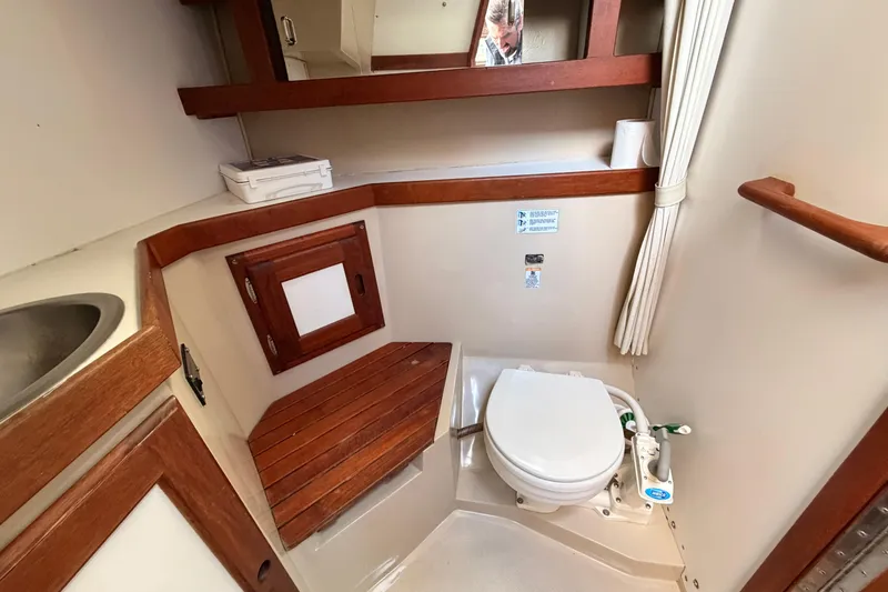 Slide: The Image of 1989 Catalina 34 yacht bathroom with wooden accents and compact design. - 34