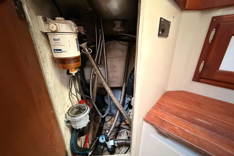 Slide: The Image of Engine compartment of a 1989 Catalina 34 sailboat, featuring fuel filter and hoses. - 36