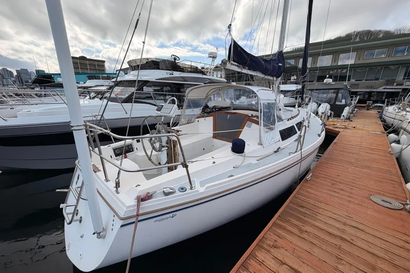 Slide: The Image of 1989 Catalina 34 sailboat docked at marina, overcast sky, surrounded by other boats. - 7