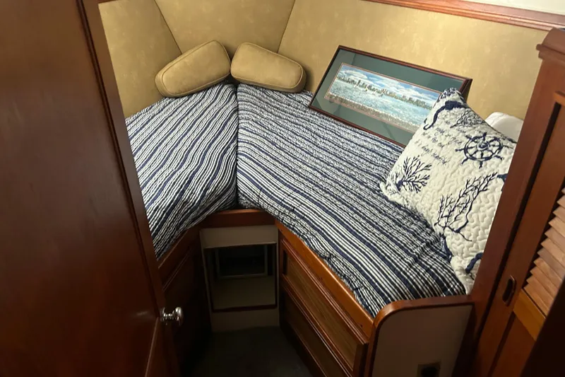 Slide: The Image of Cozy cabin interior of 1980 Trojan F44 boat with striped bedding and nautical decor. - 12