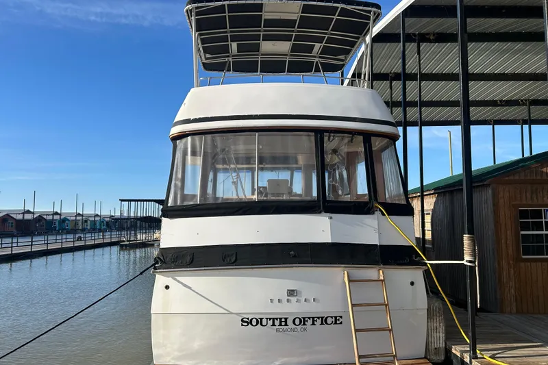 Slide: The Image of 1980 Trojan F44 boat docked, named "South Office," with clear skies and marina backdrop. - 2