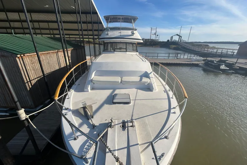 Slide: The Image of 1980 Trojan F44 yacht docked at marina under clear blue sky. - 3