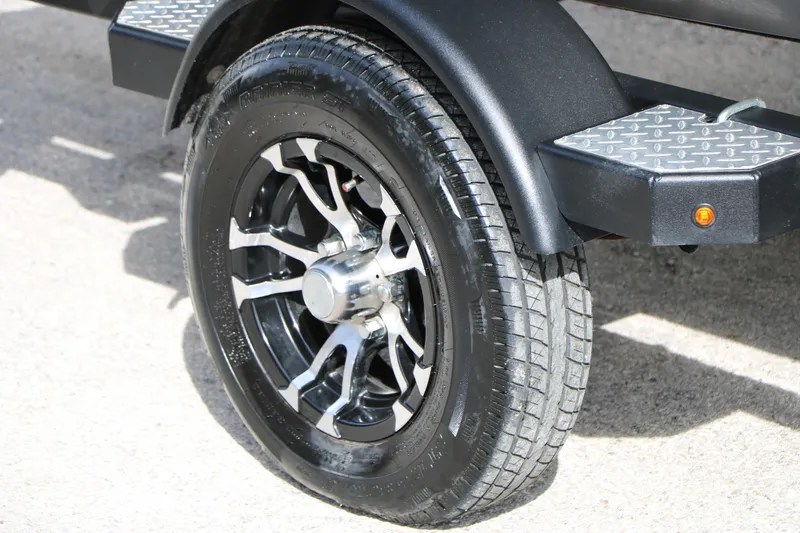 Slide: The Image of 2019 Crestliner VT 18 trailer wheel with black alloy rim and treaded tire. - 35
