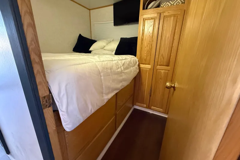 Slide: The Image of Compact bedroom in 2006 Fun Country SunCountry Arizona Edition RV with wooden cabinetry. - 15