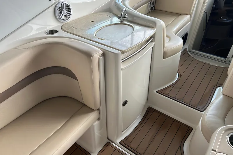 Slide: The Image of 2007 Chaparral 330 Signature boat interior with beige seating and compact kitchenette. - 26