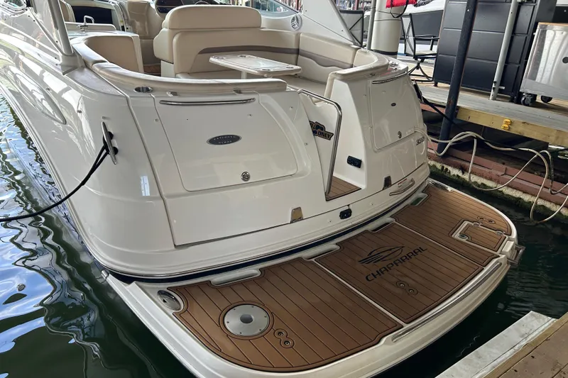Slide: The Image of 2007 Chaparral 330 Signature boat docked, showcasing elegant rear deck design. - 28