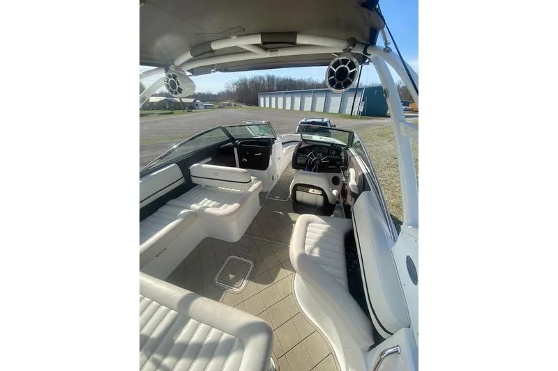 Slide: The Image of 2015 Cobalt R5 boat interior with white seating and dashboard, parked outdoors. - 15