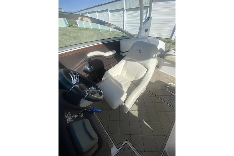 Slide: The Image of Interior of a 2015 Cobalt R5 boat featuring a white captain's chair and steering wheel. - 7